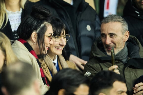 Hoshi et sa compagne Gia Martinelli, Elie Semoun - People dans les tribunes du match aller des 8èmes de finale de la ligue des champions entre le PSG et le Bayern Munich au Parc des Princes à Paris le 14 février 2023.