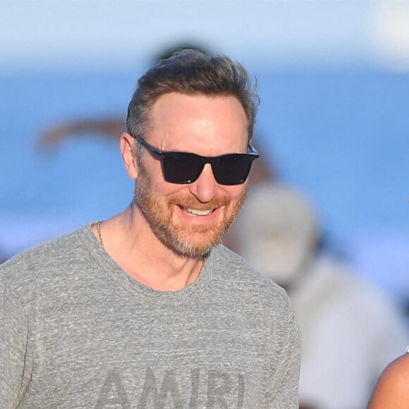 Malgré les rumeurs de séparation, David Guetta et sa compagne Jessica Ledon amoureux plus que jamais profitent d'une journée sur une plage de Miami avec leur chien le 19 février 2023.