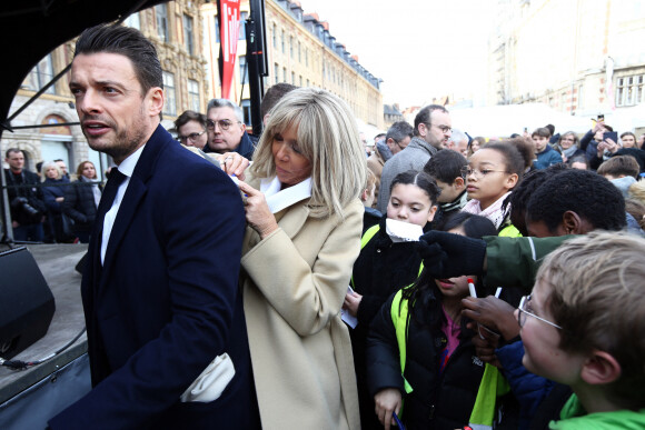 Cheveux attachés à l'aide d'une queue basse, elle prouve à nouveau qu'elle suit les dernières tendances à la lettre.
Brigitte Macron signe des autographes aux enfants des écoles lilloises à l'aide du dos de son officier de sécurité. Le 3 février 2023. © Claude Dubourg/Bestimage