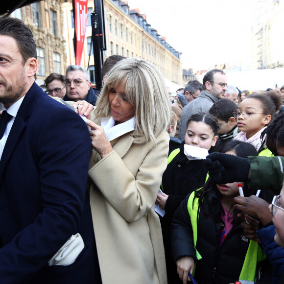 Cheveux attachés à l'aide d'une queue basse, elle prouve à nouveau qu'elle suit les dernières tendances à la lettre.
Brigitte Macron signe des autographes aux enfants des écoles lilloises à l'aide du dos de son officier de sécurité. Le 3 février 2023. © Claude Dubourg/Bestimage