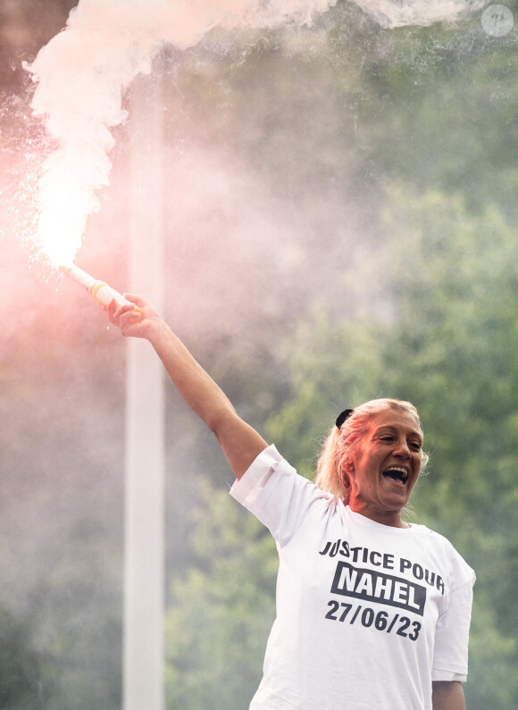 Mounia, la mère de Nahel porte un fumigène en ouverture de cortège sur le camion lors de la marche blanche organisée en hommage à Nahel jeune homme tué par un policier après un refus d'obtempérer, à Nanterre, France, le 29 juin 2023. 6 200 personnes sont présentes, selon la police. © Jean-Baptiste Autissier/Panoramic/bestimage