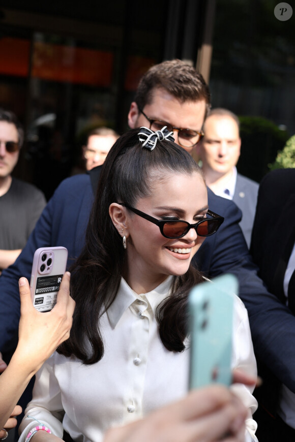 La chanteuse et actrice Selena Gomez salue les fans à la sortie de l'hôtel Bulgari à Paris, France, le 9 juin 2023.