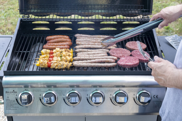 Viande cuite au barbecue chez un particulier, cuisson de la viande au barbecue a gaz, saucisses, chipolatas, brochettes et steaks haches.