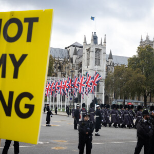 Des manifestants brandissent des panneaux "Not my King" après l'ouverture officielle du Parlement à Londres le 7 novembre 2023.