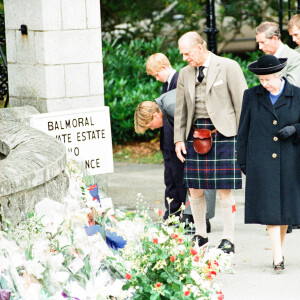 La reine Elisabeth II d'Angleterre et le prince Philip, duc d'Edimbourg, le prince Charles et ses fils le prince William et le prince Harry, devant l'entrée du château de Balmoral, où de nombreux hommages ont été rendues suite à la mort de la princesse Diana. Le 5 septembre 1997 