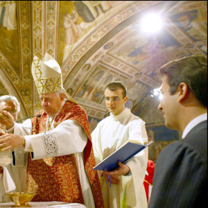 Clotilde et Emmanuel-Philibert observent le cardinal baptiser leur petite Vittoria, le 30 mai 2004 à Assise, en Italie.