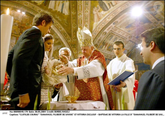 Clotilde et Emmanuel-Philibert observent le cardinal baptiser leur petite Vittoria, le 30 mai 2004 à Assise, en Italie.