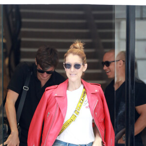 Exclusif - Céline Dion se rend chez Chanel à Paris en compagnie de son danseur Pepe Munoz qui ne la quitte plus… Le 14 juillet 2017. A la sortie, la chanteuse remarque que son chauffeur ne l'attend pas devant la boutique. En patientant, Céline fait le clown avec la pancarte "Voiturier Chanel" sous les rires du danseur. Impatients, ils décident de marcher et de se balader incognitos jusqu'au Louvre et déjeunent sur place. La star se fait vite reconnaître et s'amuse à faire des selfies avec des fans et des agents de police!