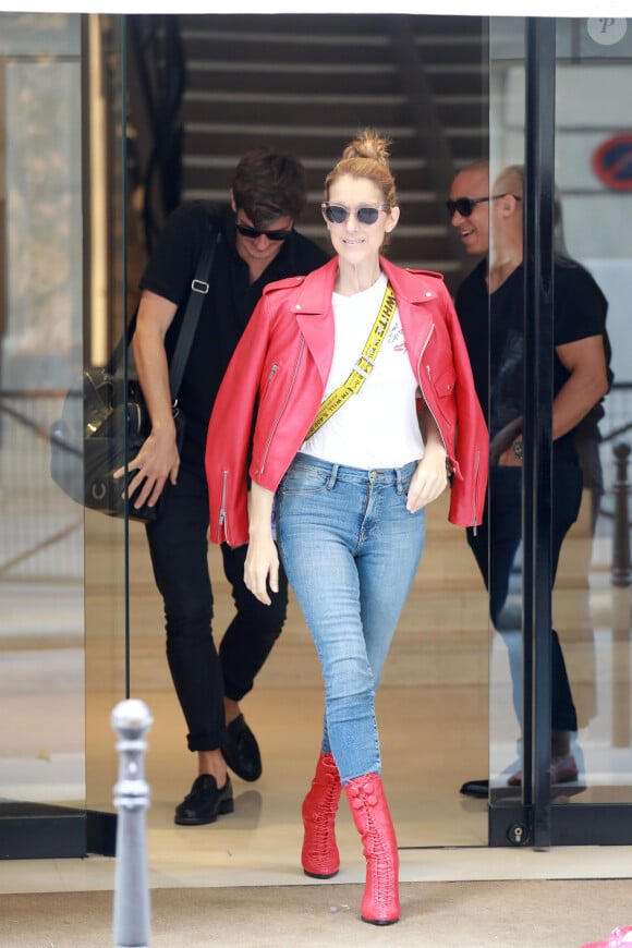 Exclusif - Céline Dion se rend chez Chanel à Paris en compagnie de son danseur Pepe Munoz qui ne la quitte plus… Le 14 juillet 2017. A la sortie, la chanteuse remarque que son chauffeur ne l'attend pas devant la boutique. En patientant, Céline fait le clown avec la pancarte "Voiturier Chanel" sous les rires du danseur. Impatients, ils décident de marcher et de se balader incognitos jusqu'au Louvre et déjeunent sur place. La star se fait vite reconnaître et s'amuse à faire des selfies avec des fans et des agents de police!