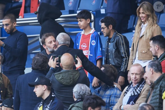 Il s'agit d'un maillot vintage du PSG datant de la saison 1996-1997
 
Ophélie Meunier, Nicolas Duvauchelle, Jamel Debbouze et son fils Léon - Célébrités dans les tribunes de la demi-finale retour de Ligue des champions entre le PSG face au Borussia Dortmund (0-1) au Parc des Princes à Paris le 7 mai 2024. © Cyril Moreau/Bestimage