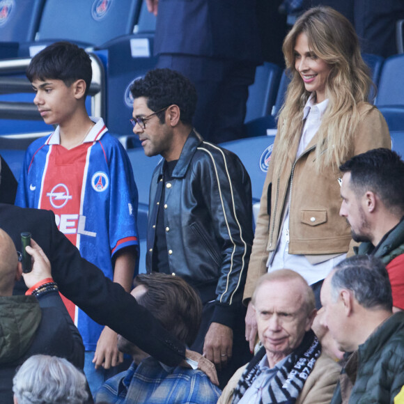 Il s'agit d'un maillot vintage du PSG datant de la saison 1996-1997
 
Ophélie Meunier, Nicolas Duvauchelle, Jamel Debbouze et son fils Léon - Célébrités dans les tribunes de la demi-finale retour de Ligue des champions entre le PSG face au Borussia Dortmund (0-1) au Parc des Princes à Paris le 7 mai 2024. © Cyril Moreau/Bestimage