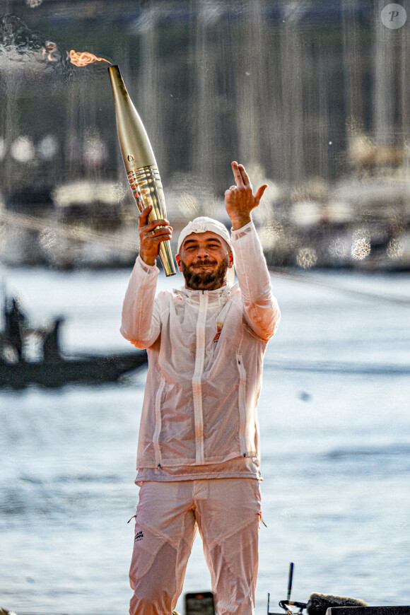 Le rappeur Jul embrase le chaudron olympique lors de la cérémonie d'arrivée de la flamme olympique au Vieux-Port de Marseille, France, le 8 mai 2024, avant les Jeux olympiques et paralympiques de Paris 2024. Le transfert de la flamme à terre d'un navire de haut du XIXème siècle marquera le début du relais de la torche olympique de 12 000 kilomètres (7500 milles) à travers la France. © Sandrine Thesillat/Panoramic/Bestimage 