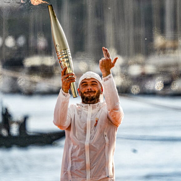 Le rappeur Jul embrase le chaudron olympique lors de la cérémonie d'arrivée de la flamme olympique au Vieux-Port de Marseille, France, le 8 mai 2024, avant les Jeux olympiques et paralympiques de Paris 2024. Le transfert de la flamme à terre d'un navire de haut du XIXème siècle marquera le début du relais de la torche olympique de 12 000 kilomètres (7500 milles) à travers la France. © Sandrine Thesillat/Panoramic/Bestimage 