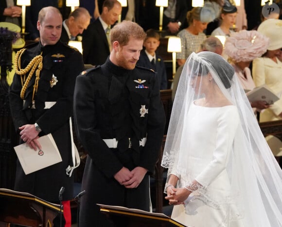 Photo d'archives datée du 19/05/2018 du prince William (à gauche) regardant le prince Harry et Meghan Markle lors de leur mariage à la chapelle St George, au château de Windsor.