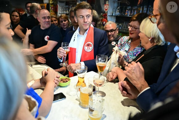 Emmanuel Macron, président de la République Française, va boire une bière dans un bar avec les habitants de Tourcoing, avant la finale de la Coupe de France 2024 "PSG - OL" au stade Pierre Mauroy. A cette occasion il se voit offrir un maillot du club du LOSC floqué avec son prénom. Tourcoing, le 25 mai 2024. © Miguel Medina/Pool/Bestimage