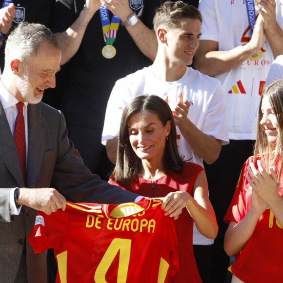 Un côté de leur tee-shirt de foot était rentré dans le jean. Être en look sportif oui, mais avec style c'est mieux.
Le roi Felipe VI et la reine Letizia d'Espagne et leurs filles, la princesse Leonor et l'infante Sofia, reçoivent l'équipe nationale de football, vainqueur de l'Euro 2024 à Madrid, le 15 juillet 2024. 