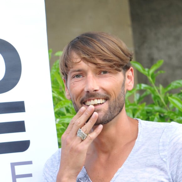 Laurent Kerusore, parrain de l'événement "Europride 2013" sur Marseille, signe la charte ethique en compagnie de l'organisatrice Suzanne Ketchian lors d'une conference de presse à Paris le 6 juin 2013