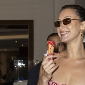 Bella Hadid, portant une tenue de style keffieh pour montrer son soutien à la Palestine, déguste une glâce à l'Hôtel Martinez pendant le 77e Festival de Cannes le 23 mai 2024. Marco Piovanotto/ABACAPRESS.COM