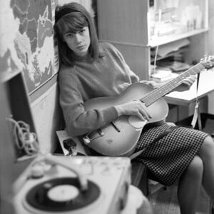 Françoise Hardy jouant de la guitare et posant dans sa maison parisienne avec un tourne-disque, le 25 novembre 1962. Mondadori Portfolio via ZUMA Press /ABACAPRESS.COM