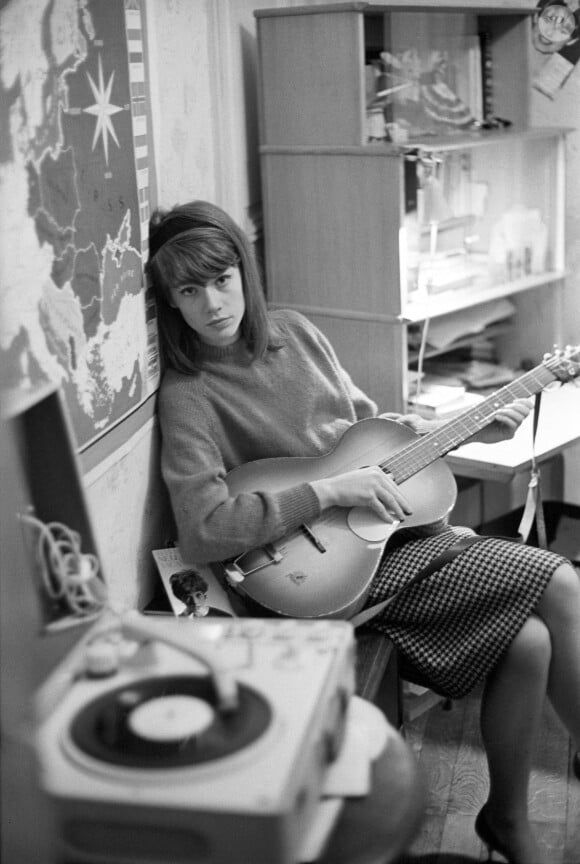 Françoise Hardy jouant de la guitare et posant dans sa maison parisienne avec un tourne-disque, le 25 novembre 1962. Mondadori Portfolio via ZUMA Press /ABACAPRESS.COM