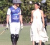 Une décision du couple qui interpelle à l'international.
Palm Beach, FL - Meghan Markle, en robe blanche et talons hauts, arrive main dans la main avec le prince Harry au Royal Salute Polo Challenge à Miami.