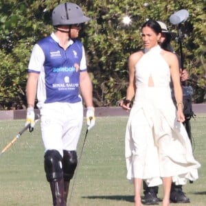 Une décision du couple qui interpelle à l'international.
Palm Beach, FL - Meghan Markle, en robe blanche et talons hauts, arrive main dans la main avec le prince Harry au Royal Salute Polo Challenge à Miami.