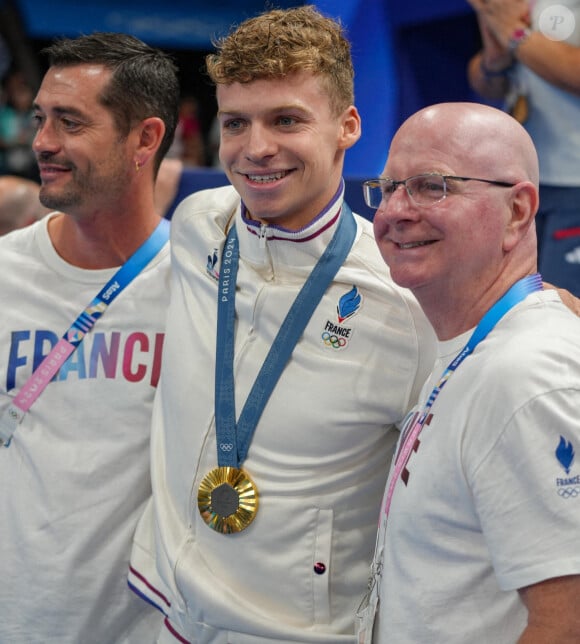 Il rentre dans l'histoire en égalant ce record, qui est aussi détenu par Michael Phelps et Mark Spitz.
Léon Marchand célèbre sa médaille d'or avec son entraîneur français, Nicolas Castel et son entraîneur américain, Bob Bowman, pendant les Jeux olympiques d'été de Paris 2024, le 2 août 2024. Pierre Costabadie/Icon Sport/ABACAPRESS.COM