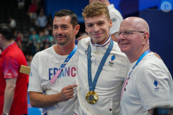 Léon Marchand célèbre sa médaille d'or avec ses entraîneurs français et américain, Nicolas Castel et Bob Bowman, le 2 août 2024. Pierre Costabadie/Icon Sport/ABACAPRESS.COM