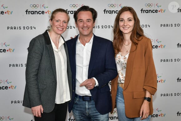 Le journaliste français Nathanael de rincquesen pose pour un photocall à côté de l'escrimeuse française Astrid Guyart et Célia Moillard avant la conférence de presse "Paris 2024" de France Télévisions à Paris le 11 juin 2024. Firas Abdullah/ABACAPRESS.COM