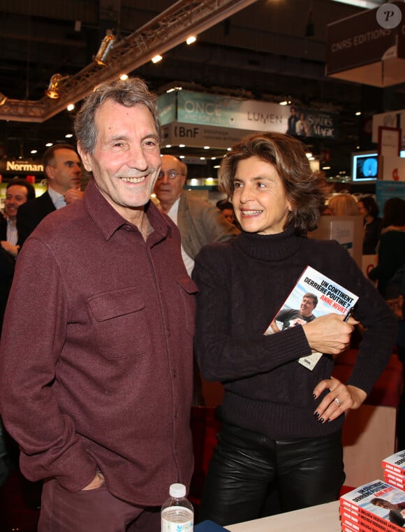 Car prochainement, Jean-Jacques Bourdin retrouvera Sud Radio où il anime un programme politique. 
Jean-Jacques Bourdin et sa femme Anne Nivat lors du salon du livre de Paris le 17 Mars 2018 à la Porte de Versailles de Paris. © Denis Guignebourg/Bestimage