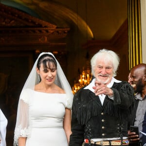 Murielle Mégevand et Hugues Aufray sur le parvis de l'église - Mariage d'Hugues Aufray et de Murielle Mégevand à l’église Saint-Vigor de Marly-Le Roy, France, le 2 septembre 2023. 