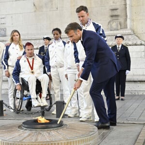 Emmanuel Macron, président de la République Française, ravive la flamme du Soldat Inconnu lors de la "Parade des Champions" des Jeux Olympiques et Paralympiques de Paris2024, le 14 septembre 2024. © Eric Tschaen/Pool/Bestimage 