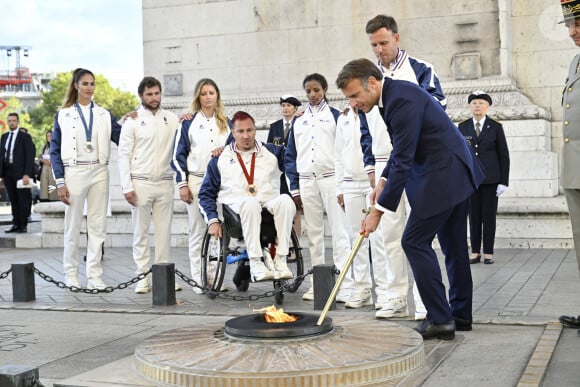 Emmanuel Macron, président de la République Française, ravive la flamme du Soldat Inconnu lors de la "Parade des Champions" des Jeux Olympiques et Paralympiques de Paris2024, le 14 septembre 2024. © Eric Tschaen/Pool/Bestimage 