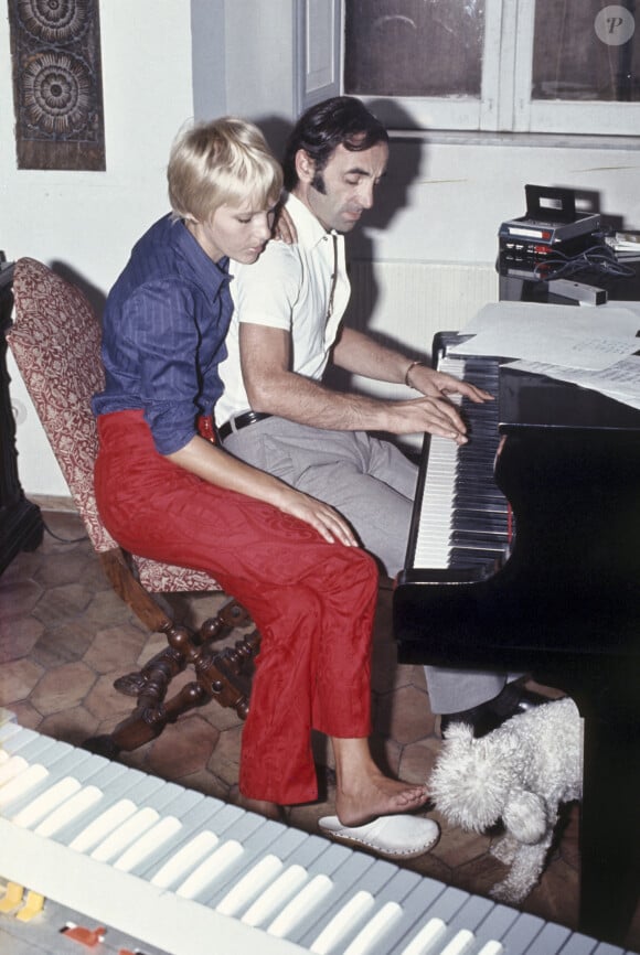 L'auteur-compositeur-interprète français d'origine arménienne Charles Aznavour joue un thème au piano ; à côté de lui est assise sa troisième épouse, la Suédoise Ulla Thorsell, qui caresse du pied un caniche blanc, tandis qu'en gros plan se détache un clavier. Italie, 1968. Photo de Giorgio Ambrosi/Mondadori Portfolio via ZUMA Press/ABACAPRESS.COM