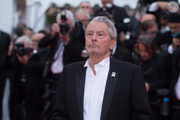 Le 18 août dernier, Alain Delon a rendu son dernier souffle à l'âge de 88 ans, laissant derrière lui des proches et fans éplorés.
Alain Delon (Palme d'Or d'Honneur du 72ème festival de Cannes avec un badge Paris Match d'une ancienne couverture du magazine titrant "Alain Delon, mes deux amours, Rosalie et Anouchka) - Montée des marches du film "A Hidden Life" lors du 72ème Festival International du Film de Cannes. Le 19 mai 2019 