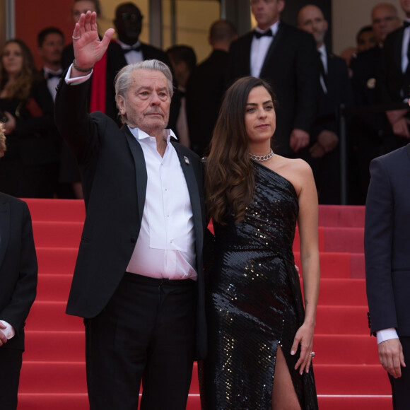 Alain Delon (Palme d'Or d'Honneur du 72ème festival de Cannes avec un badge Paris Match d'une ancienne couverture du magazine titrant "Alain Delon, mes deux amours, Rosalie et Anouchka) et sa fille Anouchka (Robe Elie Saab) - Montée des marches du film "A Hidden Life" lors du 72ème Festival International du Film de Cannes. Le 19 mai 2019 