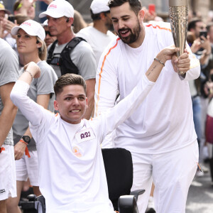 Artus, comédien et humoriste français, et Sofian Ribes, créateur de contenu, lors du torch kiss relai de la Flamme Olympique à Montpellier pour les Jeux Olympiques de Paris 2024, le 13 mai 2024. 