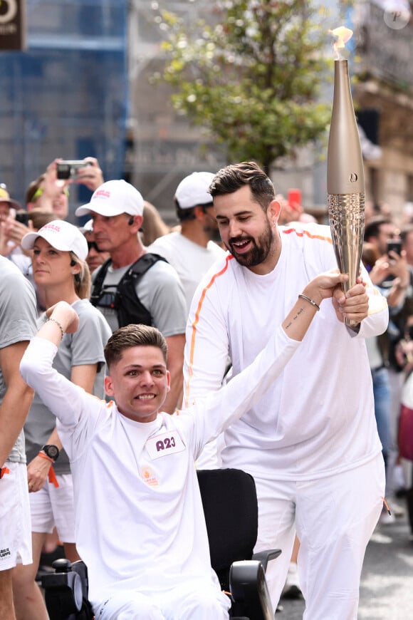 Artus, comédien et humoriste français, et Sofian Ribes, créateur de contenu, lors du torch kiss relai de la Flamme Olympique à Montpellier pour les Jeux Olympiques de Paris 2024, le 13 mai 2024. 