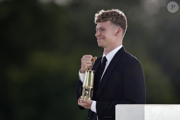 Le nageur français Leon Marchand porte la flamme olympique au Jardin des Tuileries lors de la cérémonie de clôture des Jeux olympiques de Paris 2024, au Stade de France, Paris. Paris, France, le 11 août 2024. Photo par Tolga Akmen/POOL/PA Wire/ABACAPRESS.COM