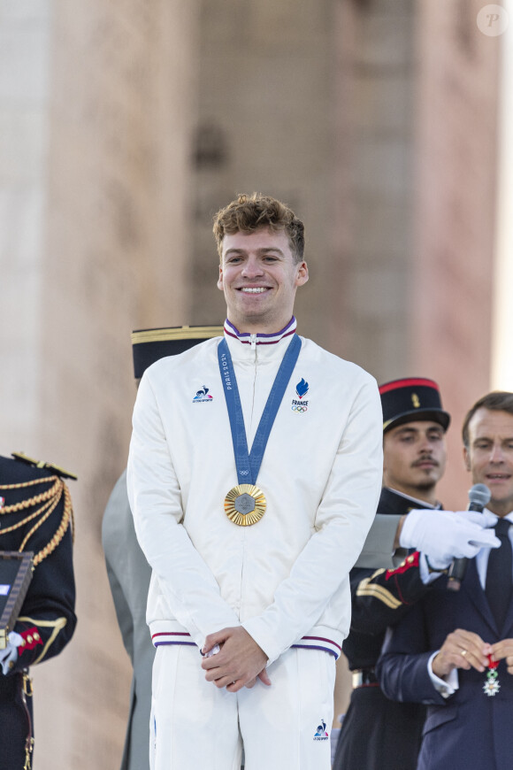 Léon Marchand, Emmanuel Macron - Remise des médailles par le président de la République à l'Arc de Triomphe aux athlètes lors de la parade des champions à l'occasion des Jeux Olympiques et Paralympiques Paris 2024, sur l'avenue des Champs-Elysées à Paris. Le 14 septembre 2024 © Perusseau-Ramsamy / Bestimage