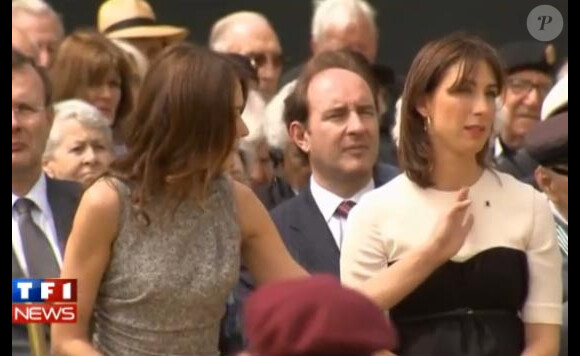 Carla Bruni retire délicatement une mouche posée sur le corset de l'épouse de David Cameron lors de la commémoration du 70e anniversaire de l'Appel du 18 juin 1940 à Londres, le 18 juin 2010