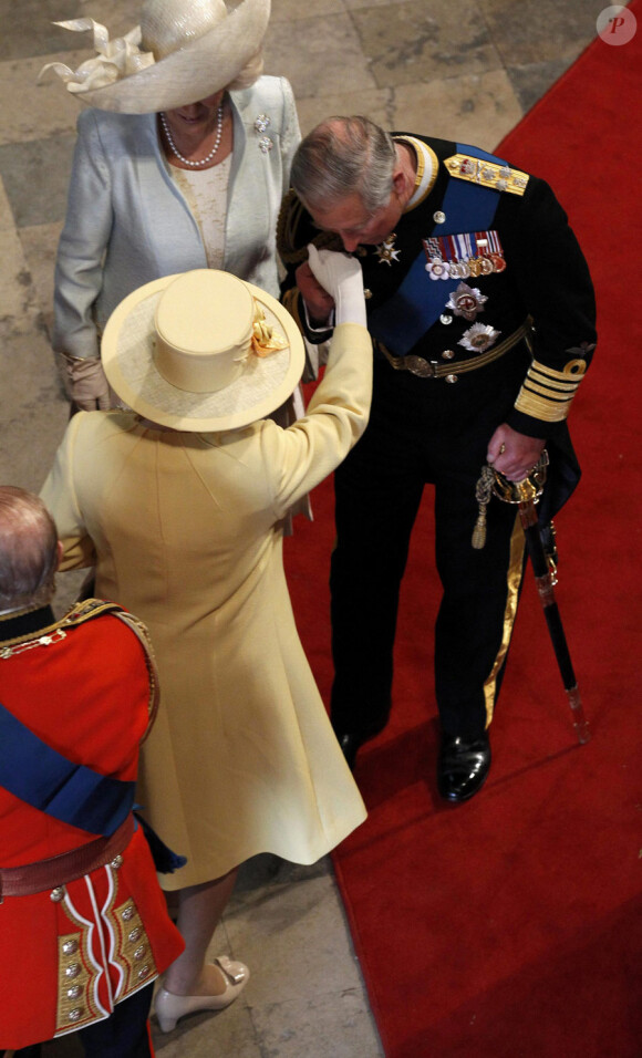 Le Prince Charles fait le baise-main à sa mère la Reine Elizabeth en arrivant à l'Abbaye de Westminster pour assister au mariage de Kate Middleton avec le Prince William, le 29 avril 2011