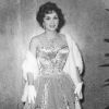L'Italienne Gina Lollobrigida porte une robe typiquement années 50, corsetté pour mettre la poitrine et la taille de guêpe en valeur. Gênes, 1958