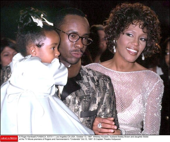 Whitney Houston est radieuse en 1997 au bras de son époux Bobby Brown, qui porte leur fille Bobbi Kristina, pour la première de Rodger and Hammerstein's Cinderella.