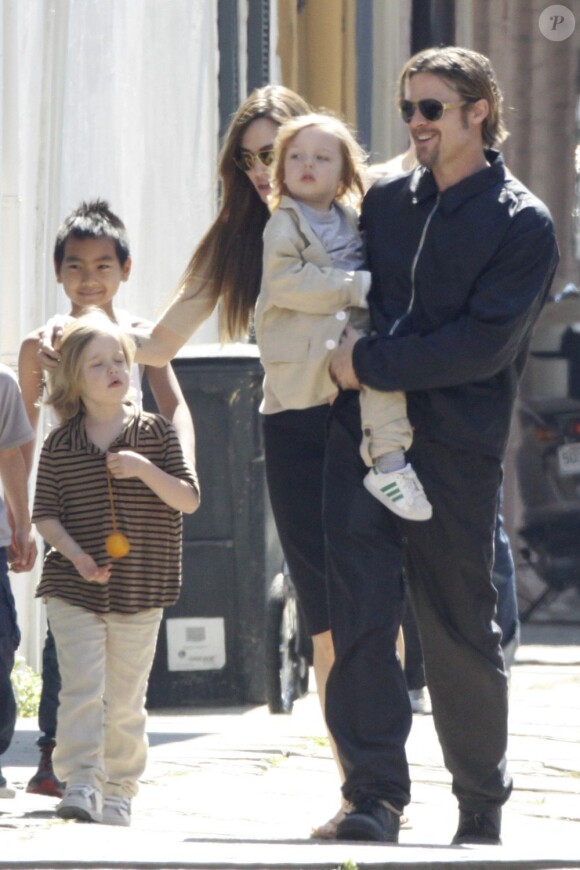 Angelina Jolie et Brad Pitt qui porte dans ses bras Knox, en mars 2011 à la Nouvelle Orléans. En arrière plan, Shiloh et Maddox