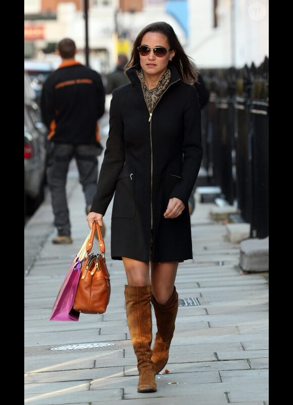 Inséparable de son sac Modalu, elle décide de l'assortir à des bottes à semelle plate : grossière erreur. Londres, le 25 octobre 2011.