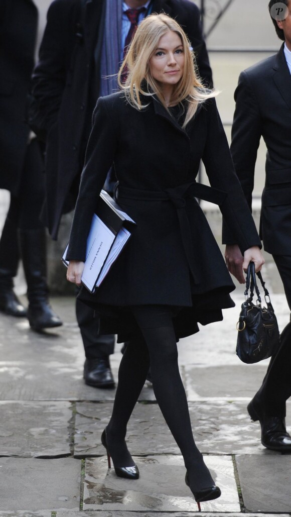 Sienna Miller, inspirée par Victoria Beckham et ses robes manteaux, ose le même look pour se rendre à la Haute Cour de justice. Londres, le 24 novembre 2011.