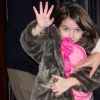 Suri Cruise fait coucou aux photographes en compagnie de sa maman Katie Holmes et Tom Cruise à New York le 20 décembre 2011