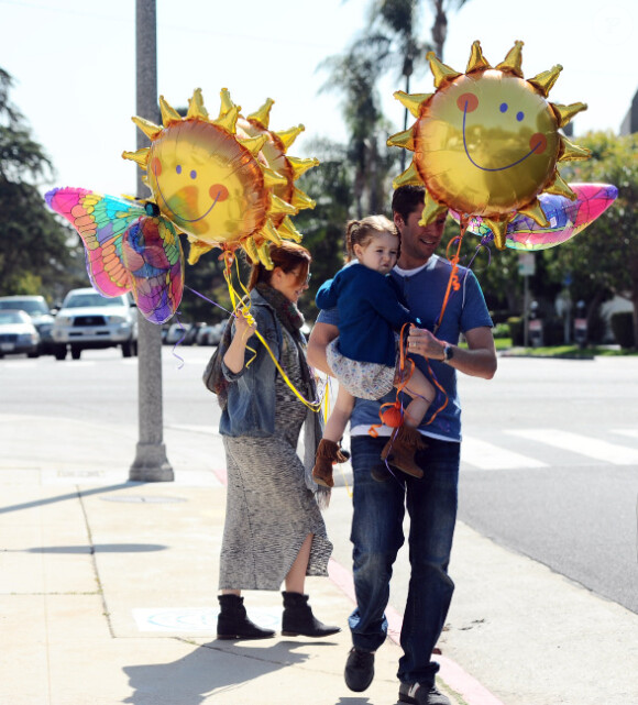 Derrière les ballons : Alyson Hannigan, son époux Alexis Denisof et leur fille Satyana, à Los Angeles le 3 mars 2012.