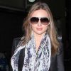 Miranda Kerr, à l'aéroport de Los Angeles, twiste son look classique avec une écharpe imprimée signée Balmain. Le 22 avril 2012.